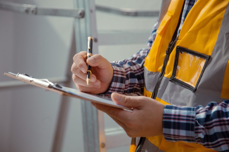 stock-photo-building-contractor-check-and-write-down-the-details-of-the-construction-wearing-yellow-2023293038