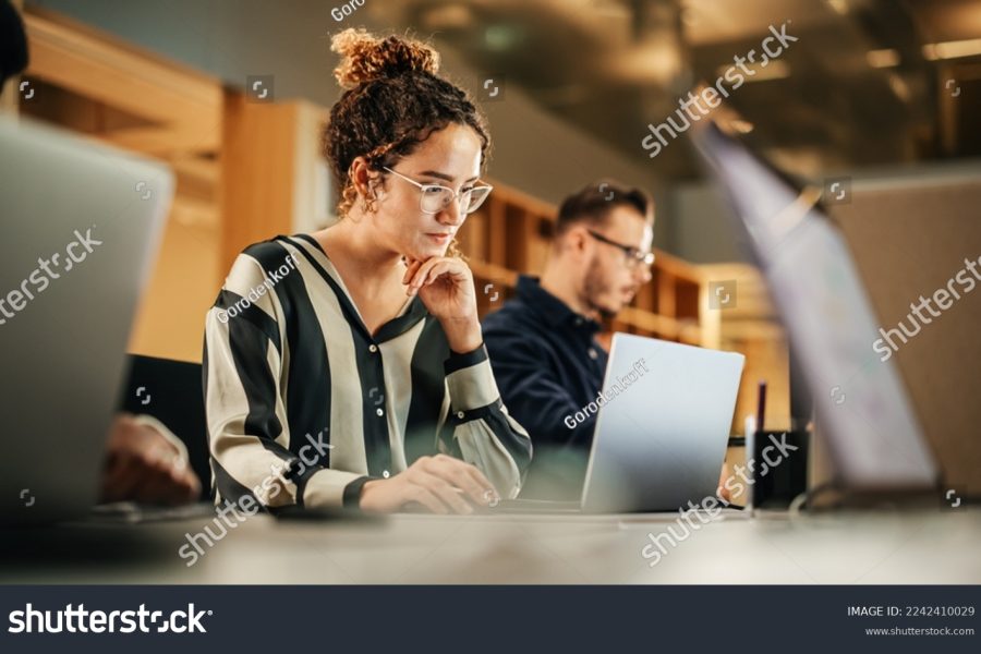 stock-photo-portrait-of-enthusiastic-hispanic-young-woman-working-on-computer-in-a-modern-bright-office-2242410029